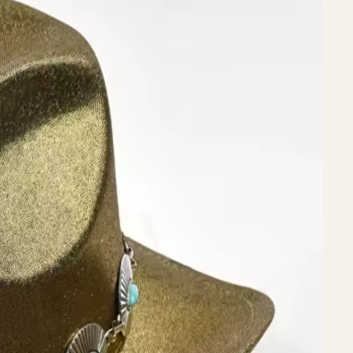 Close-up of champagne gold sequin texture and concho band on cowboy hat