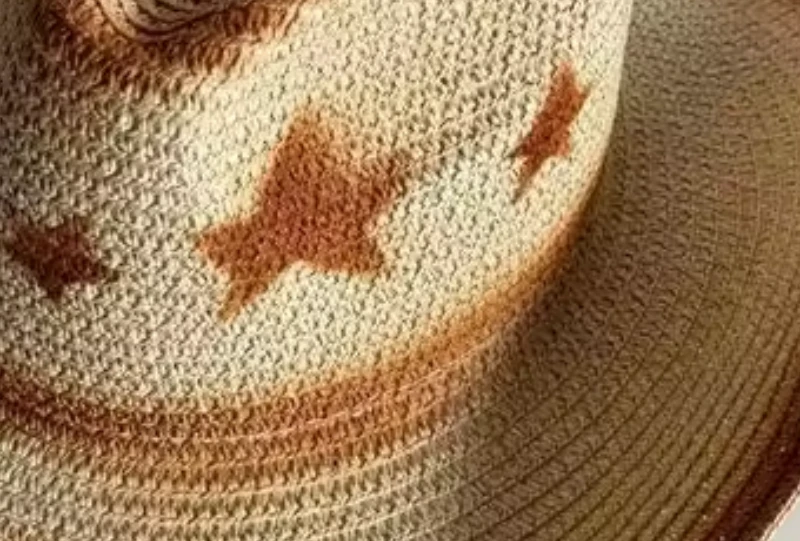 Close-up of hand-woven natural straw texture and star pattern on cowboy hat band