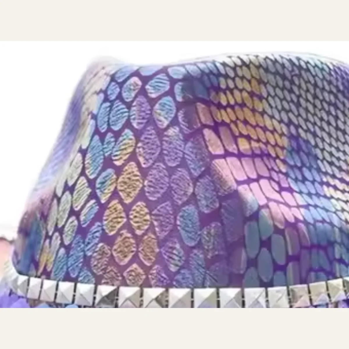 Close-up of iridescent purple snakeskin-pattern sequin texture on disco cowboy hat