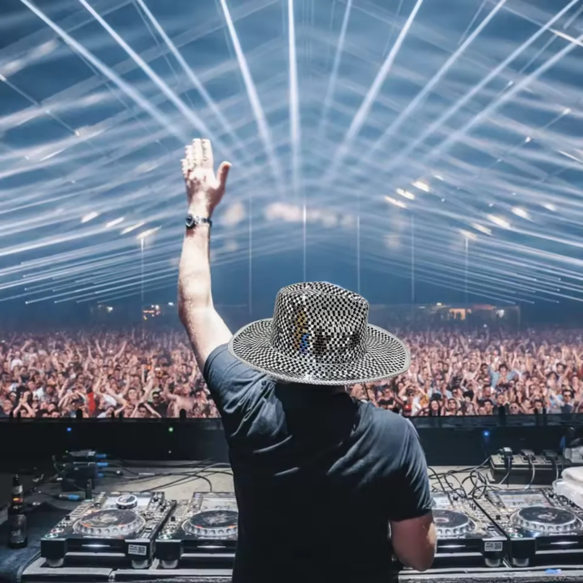 DJ wearing the Silver Mirror Disco Cowboy Hat on stage at a festival with laser lights