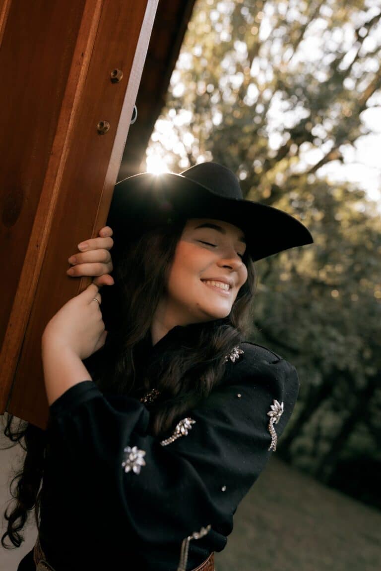 Woman wearing an elegant felt cowboy hat outdoors, styled for a western wedding guest outfit