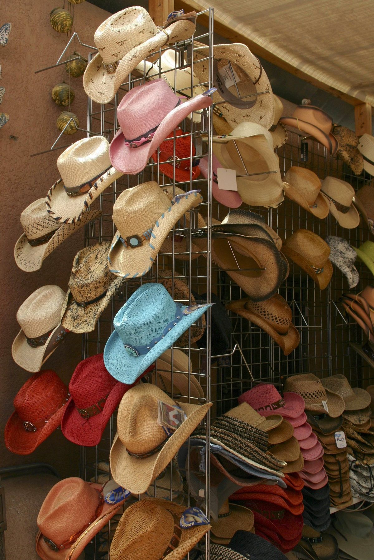 Colorful selection of cowboy hats displayed on a shop rack, illustrating different cowboy hat color options